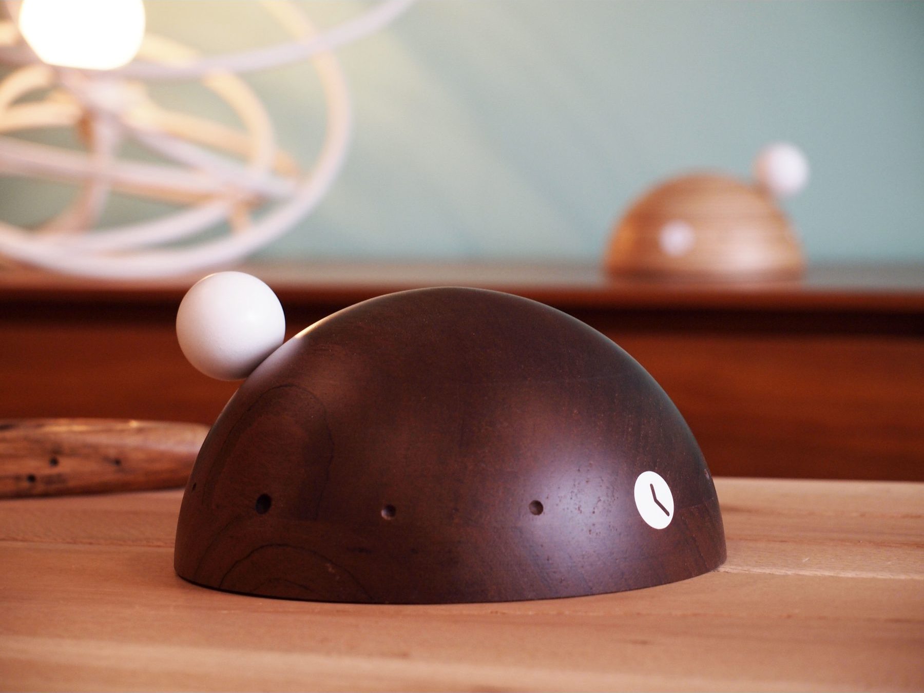 Reloj de sobremesa Dome en madera oscura, con su pequeña bola blanca